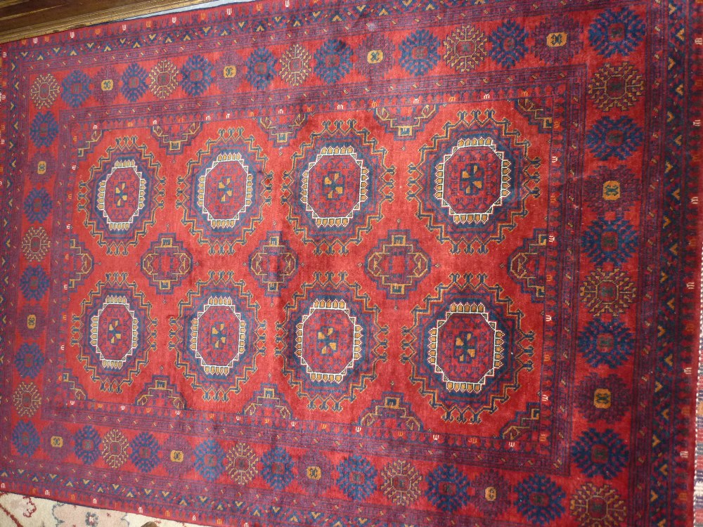 Modern Afghan Belouch rug with two rows of four gols on a wine ground with borders and Kelim ends,