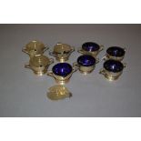 Set of eight London silver condiments with blue glass liners (one a/f)