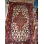 Small Hamadan mat with a single medallion and all-over design on an ivory ground with borders,