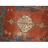 Kurdish rug with a single lobed medallion design on a red ground with multiple border,