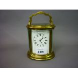 Early 20th Century oval gilt brass carriage clock, the enamel dial with Roman numerals,