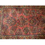 Sarouk runner with all-over floral design and multiple borders on a pink ground,