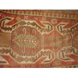 Kurdish rug with a triple hooked medallion design in shades of red,