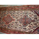 Hamadan runner with triple medallion and all-over design on an ivory ground with borders,