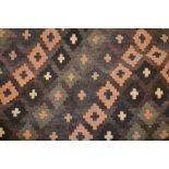 Large Kelim rug with diamond design with multiple borders on a wine ground,