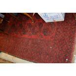 Afghan carpet with three rows of seven gols on a wine red ground,