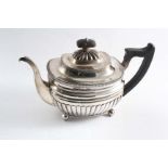 A GEORGE III PART-FLUTED TEA POT on ball feet with a gadrooned border & domed cover, by Stephen