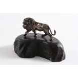 A LATE 20TH CENTURY SOUTH AFRICAN MINIATURE CAST FIGURE OF A LION with his forepaw raised and his