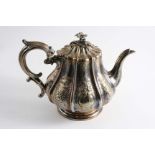 A VICTORIAN IRISH TEA POT with a fluted, pear-shaped body chased with floral sprays and two vacant