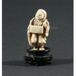 TWO JAPANESE NETSUKE, the first of a man standing with a box hung from his neck, height 5.2cm,
