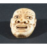 FOUR JAPANESE IVORY NETSUKE, the first carved as a grinning mask, height 4.3cm, together with a