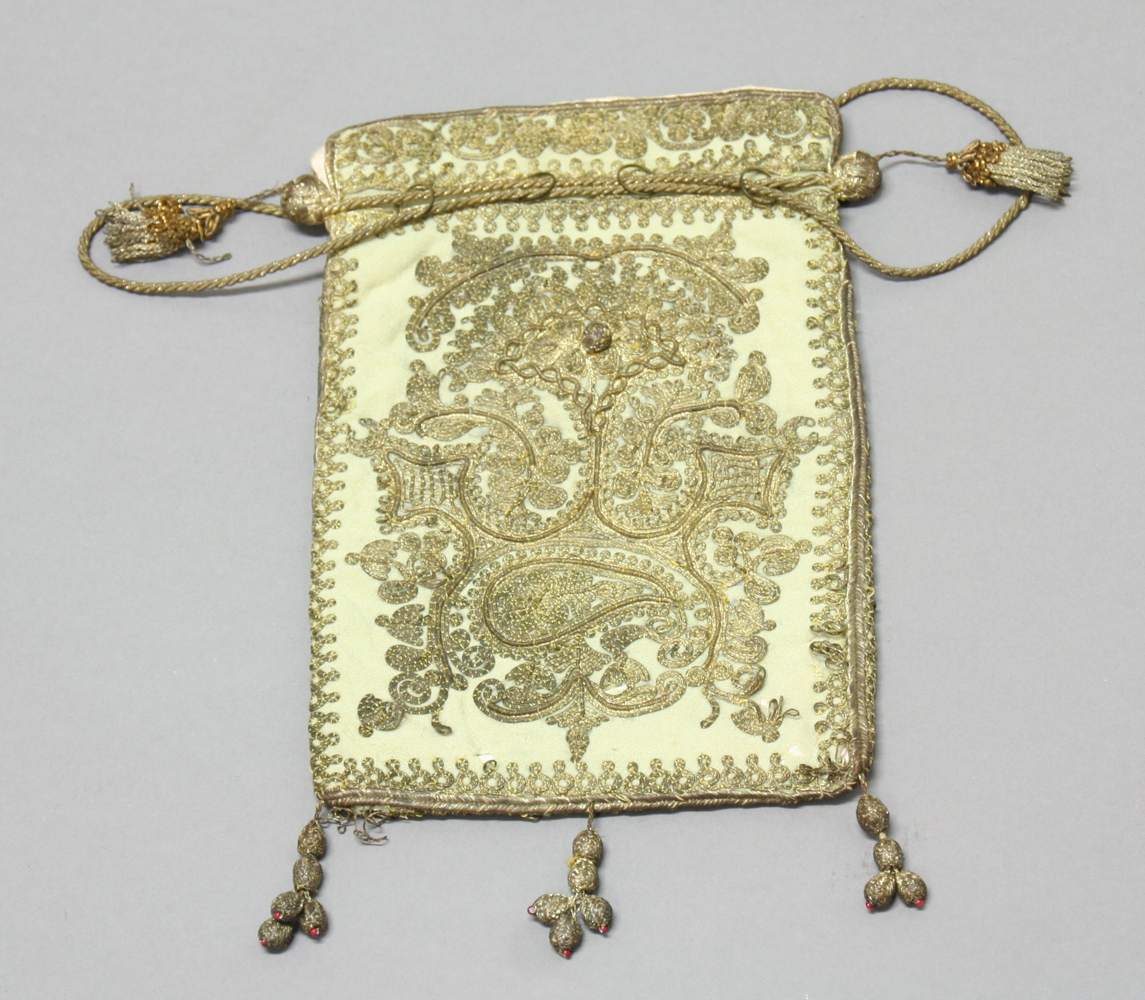 INDO-PERSIAN GILT WIRE WORK BAG, the floral design in relief, on a cream ground, 27cm x 17cm