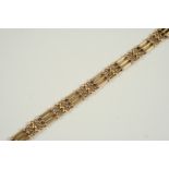 A 15CT. GOLD FANCY GATE LINK BRACELET with concealed clasp, damaged, 17.5cm. long, with extra links,