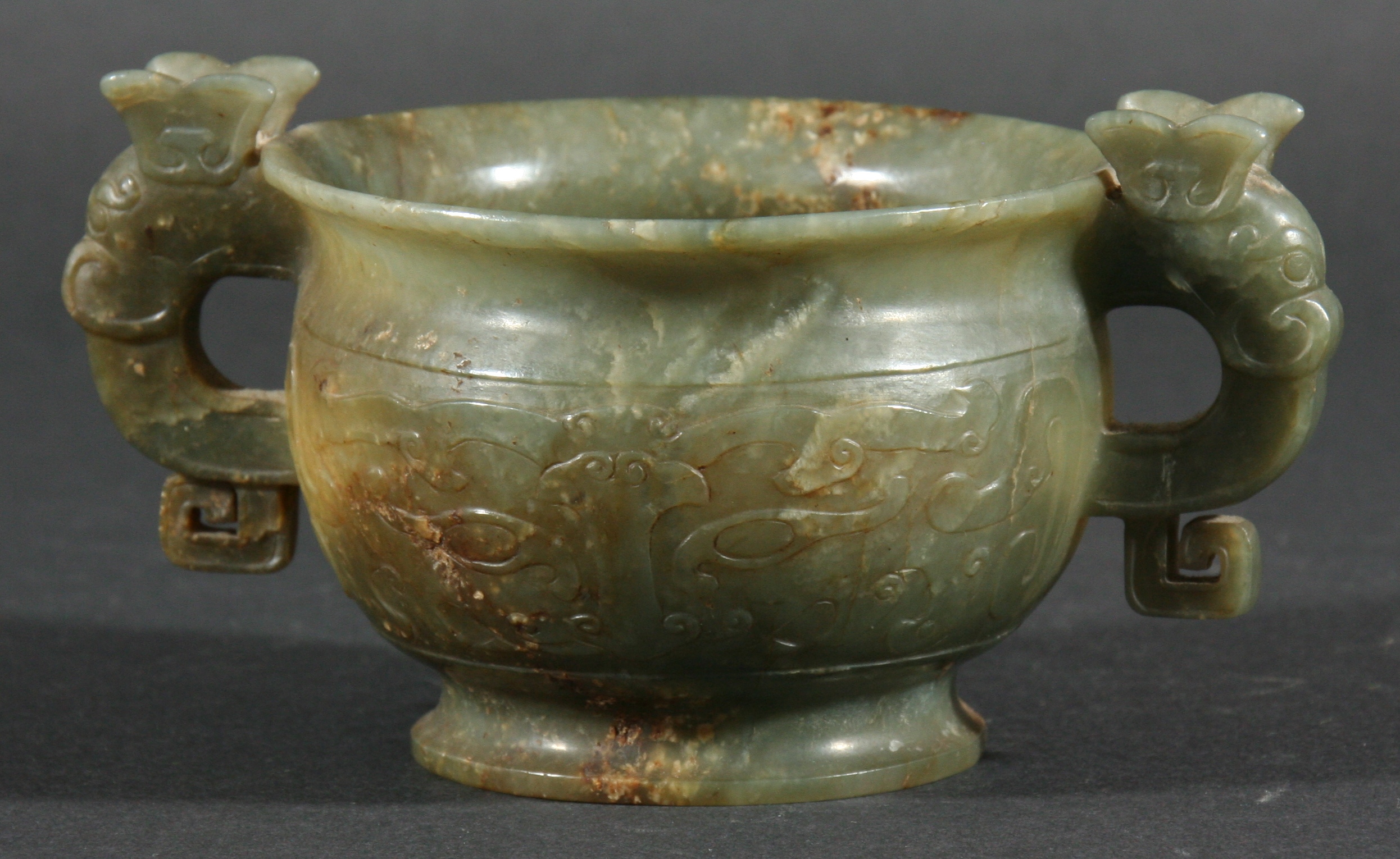 CHINESE GREEN AND RUSSET JADE CENSER, of two handled form, carved in low relief with stylised dragon