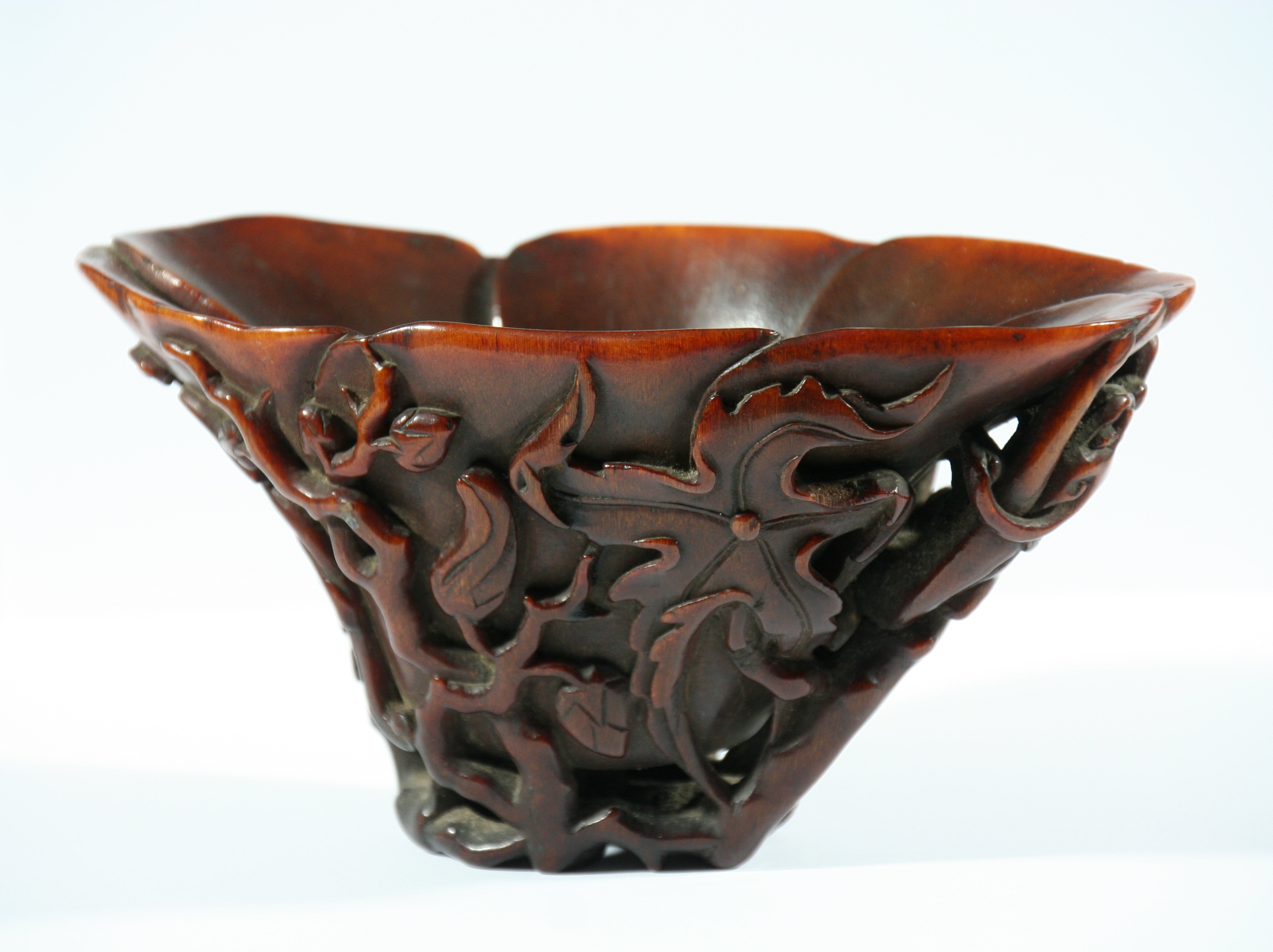 CHINESE RHINOCEROS HORN LIBATION CUP, 19th century, carved with dragons amongst scrolling foliage,