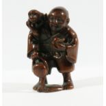 THREE JAPANESE HARDWOOD NETSUKE, the first carved as a man with a monkey, signed, height 5.2cm,