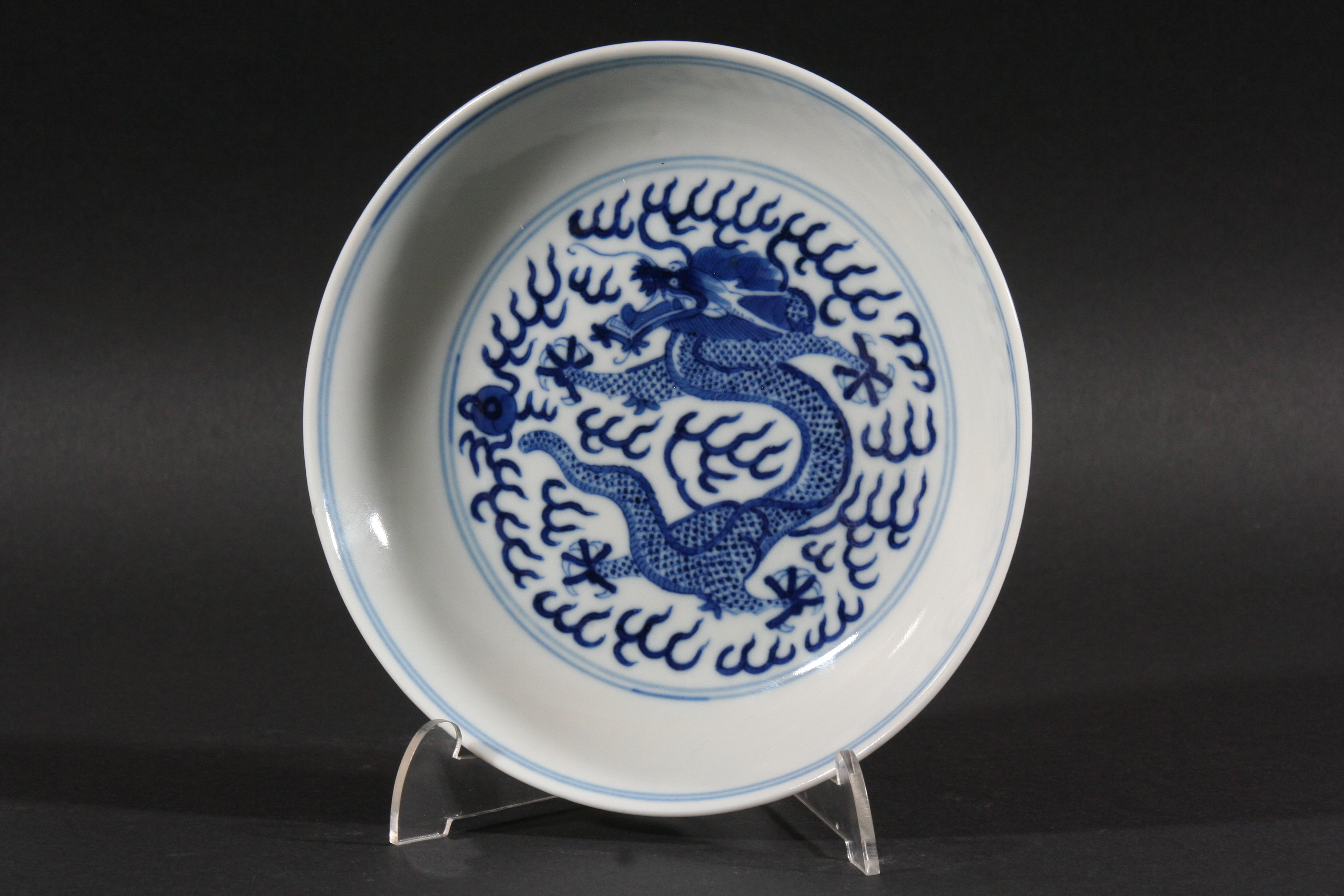 CHINESE SAUCER DISH, Qing Dynasty, blue painted with a central dragon chasing the flaming pearl