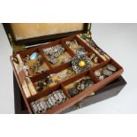 A LEATHER JEWELLERY BOX containing various items of paste set jewellery and costume jewellery.