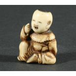 TWO JAPANESE NETSUKE, of a boy seated hiding a mask behind his back, height 3.7cm, the other