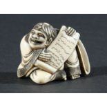 JAPANESE IVORY NETSUKE, carved as a grinning man holding a scroll, height 4.5cm