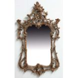 18TH CENTURY STYLE GILT MIRROR, the shaped rectangular plate inside a scrolling foliate frame