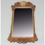 GEORGE II STYLE WALNUT WALL MIRROR, the bevelled, shaped rectangular mirror inside a scrolling frame