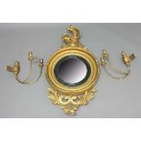 REGENCY STYLE BULL'S EYE MIRROR, 19th century, the circular convex plate flanked by a pair of two