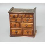 MINIATURE CHEST OF DRAWERS, mahogany veneered with various crossbanding patterns to the nine
