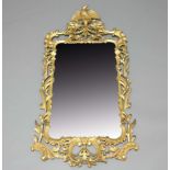 GEORGE III STYLE CARVED GILT WOOD MIRROR, 19th century, the shaped rectangular plate inside a gilt