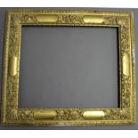 A GILDED PICTURE FRAME with a faint ribbon-twist outer band, the border with shaped reserves and