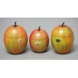 THREE APPLE TEA CADDIES, 19th century, naturalistically painted in red and green, heights 17cm and