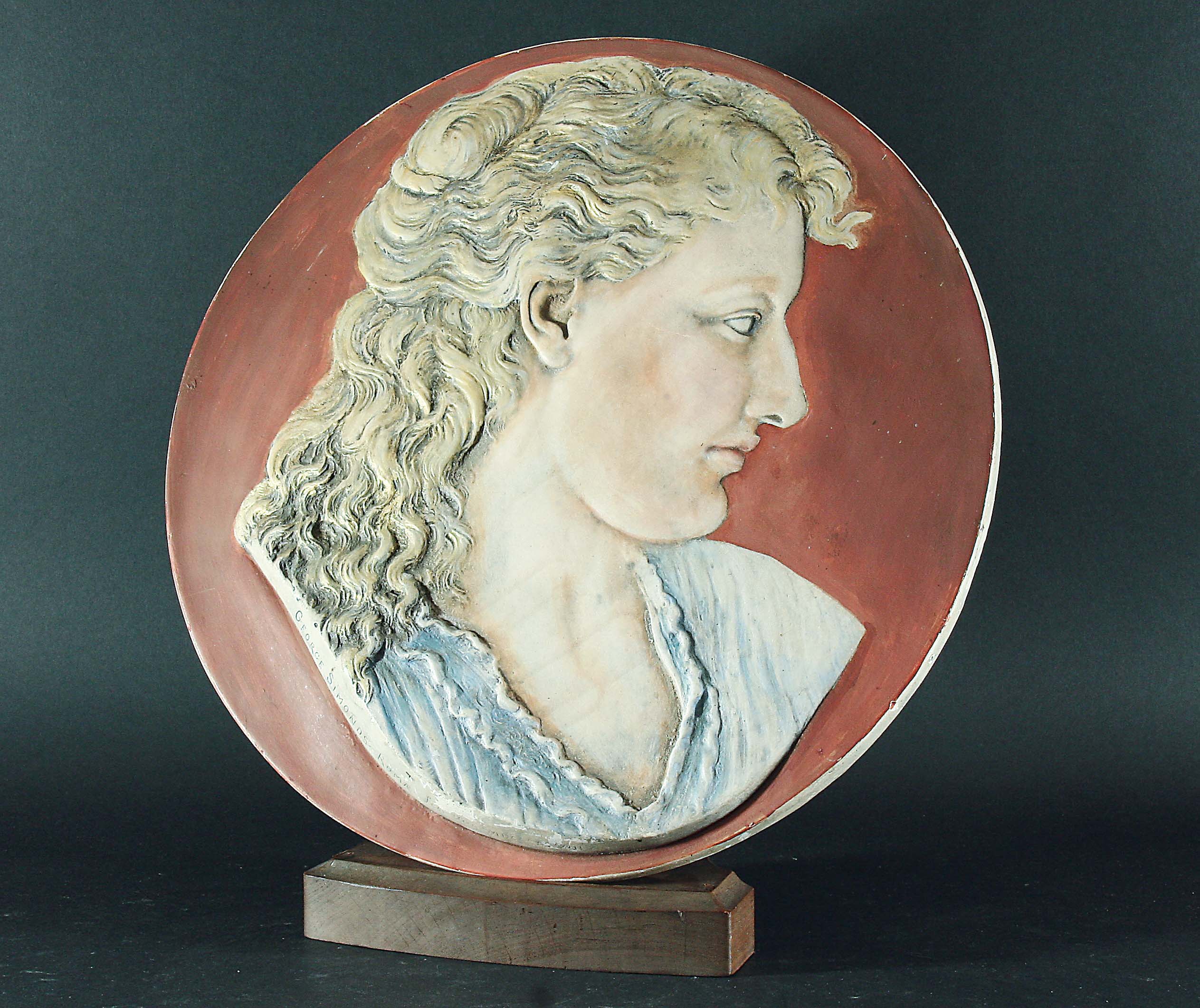 GEORGE BLACKALL SIMONDS Circular Stoneware Plaque with a bust of a Preraphaelite style classical