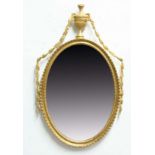 NEO-CLASSICAL GILT GESSO WALL MIRROR, the oval plate in a rope twist frame with urn and swag finial,