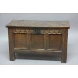 OAK COFFER, 18th century, the hinged cover enclosing a vacant interior above a triple panel front,