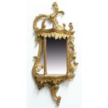 GEORGE III CHIPPENDALE STYLE WALL MIRROR, 19th century, of rococo form, with scrolling and foliate