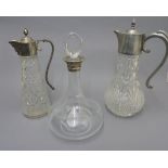 CARTIER SILVER AND GOLD RIMMED DECANTER AND TWO CLARET JUGS