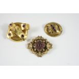 A VICTORIAN GOLD BROOCH oval, of scrolling form, set with three oval-shaped garnets, 3.5cm. wide,