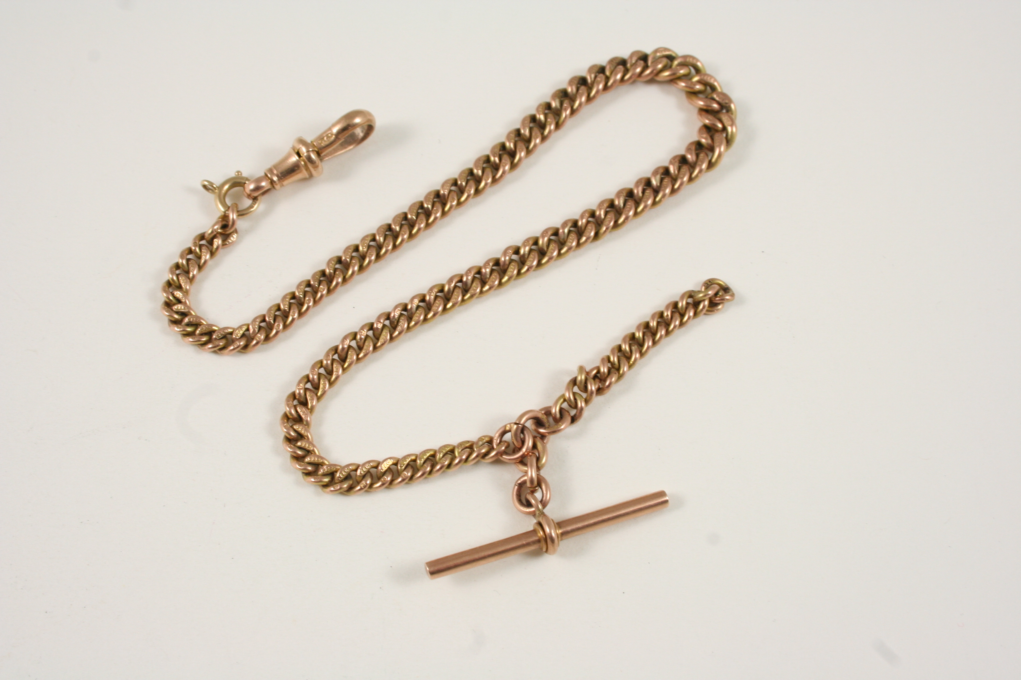 A 9CT. GOLD CURB LINK WATCH CHAIN with gold 't' bar, 27.5cm. long, 23.8 grams.