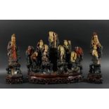 CHINESE SOAPSTONE FIGURAL GROUP, modelled as nine immortals on rocky plinths, flanked by two