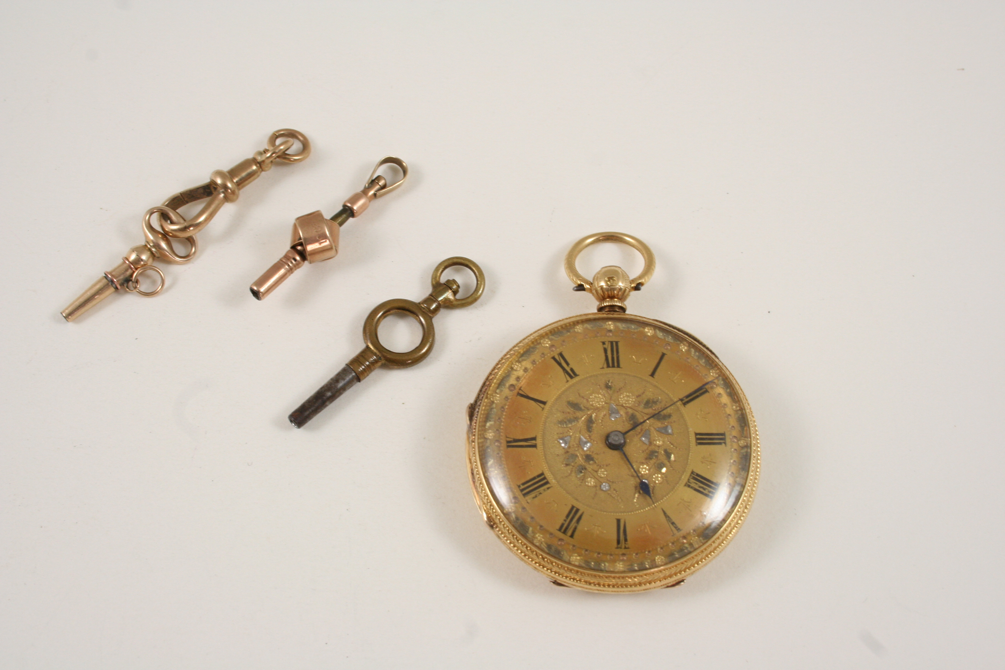 AN 18CT. GOLD OPEN FACED POCKET WATCH the gold foliate engraved dial with Roman numerals, with