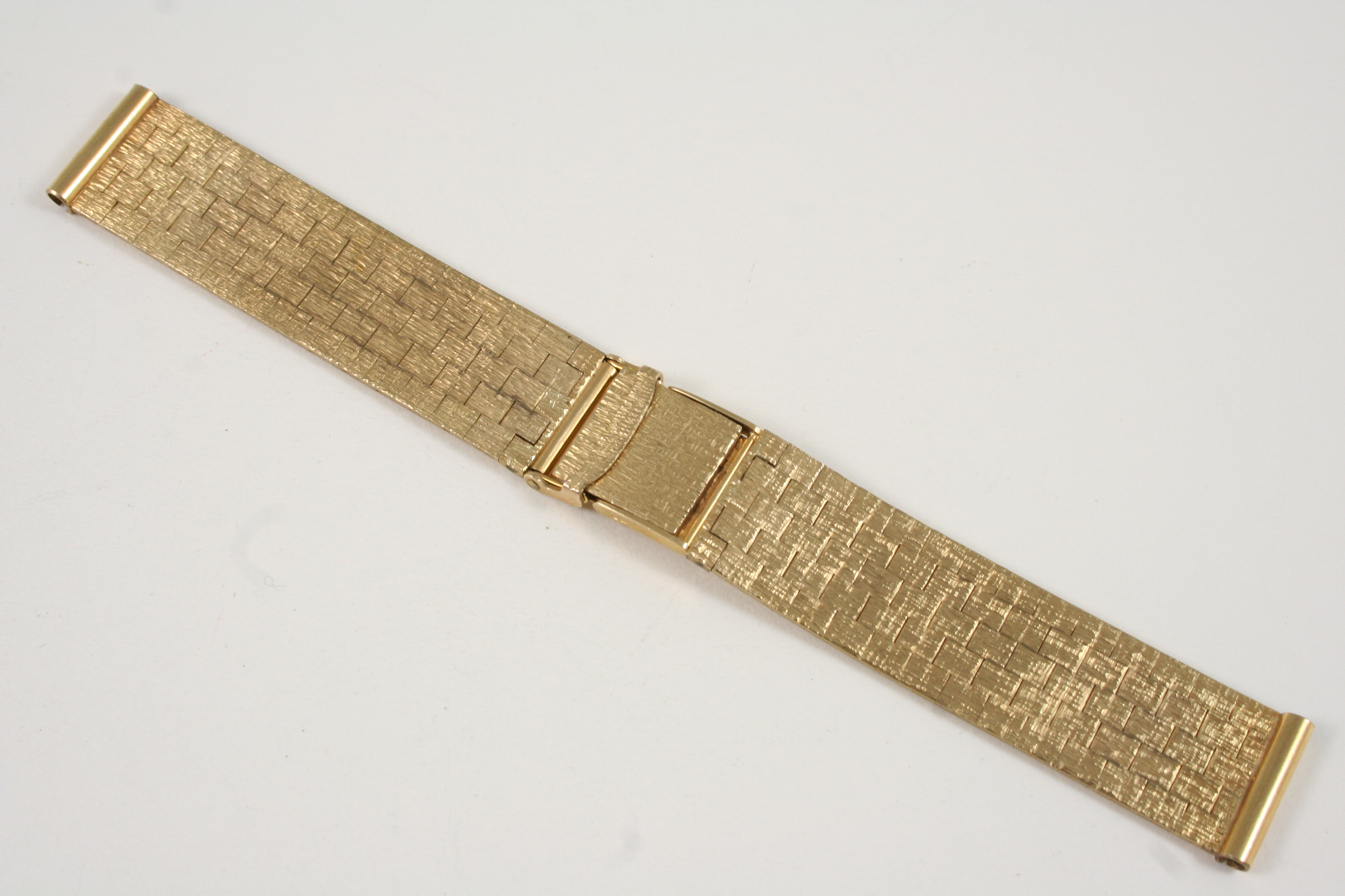 A 9CT. GOLD WRISTWATCH STRAP of granulated brick link design, with ladder clasp with saftely bar,