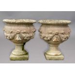 PAIR OF RECONSTITUTED STONE URNS, with floral and ribbon swags on socle bases, height 68cm (2)