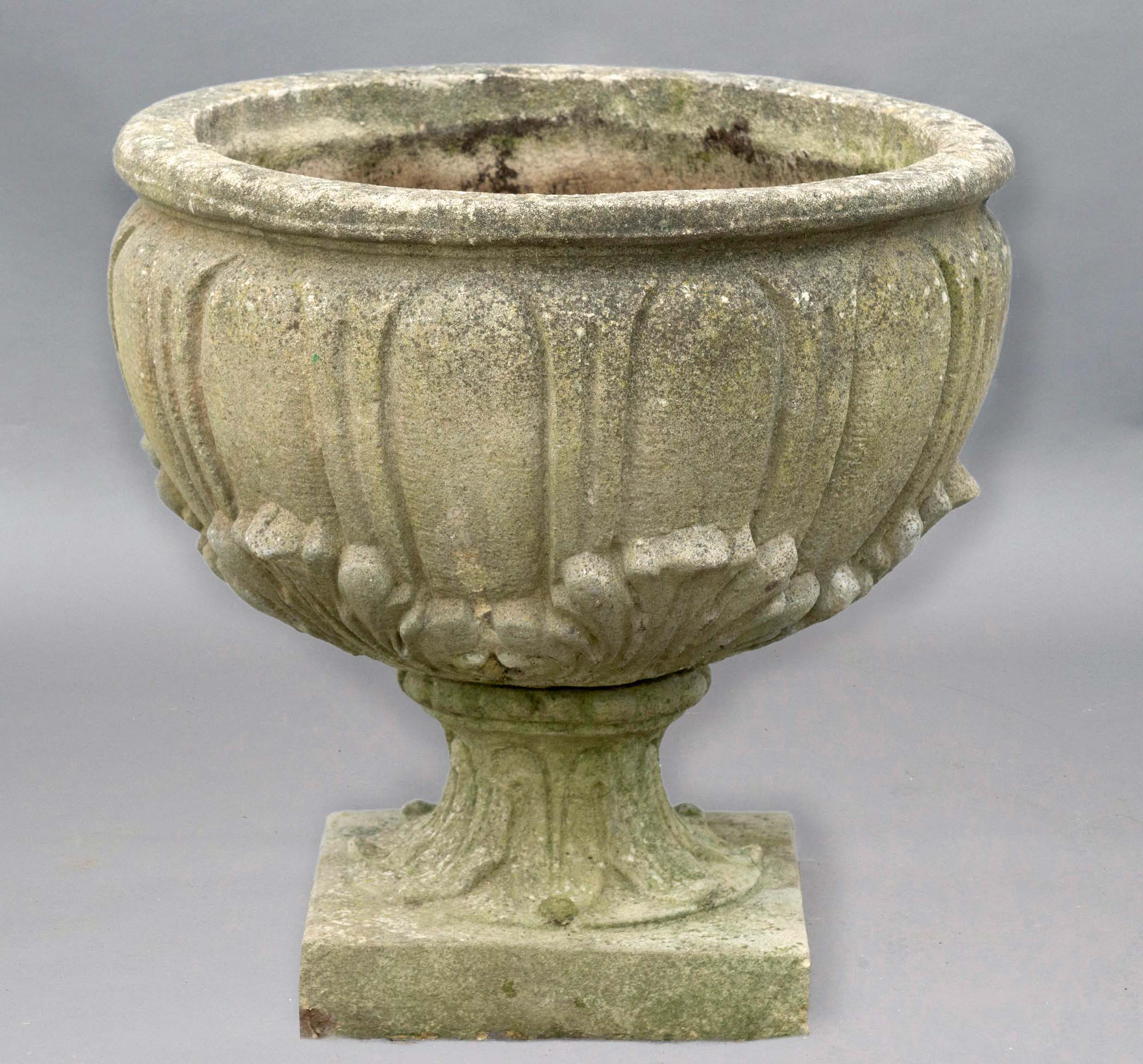 RECONSTITUTED STONE URN, with egg and dart and moulded leaf decoration, on a foliate cast foot,