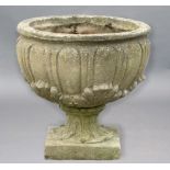 RECONSTITUTED STONE URN, with egg and dart and moulded leaf decoration, on a foliate cast foot,