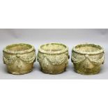 SET OF THREE CAST STONE PLANTERS, of ovoid form with swag decoration, height 32cm, diameter 42cm (