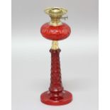 VICTORIAN RUBY GLASS OIL LAMP, the ovoid reservoir with oval facets, on a tapering faceted glass