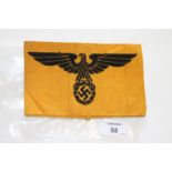 A GERMAN ARMBAND. A Nazi Armband in mustard cloth with black Eagle over Swaztika design, official