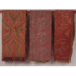 THREE WOVEN WOOL PAISLEY SHAWLS. A woven wool paisley shawl in reds and gold's. Good condition.