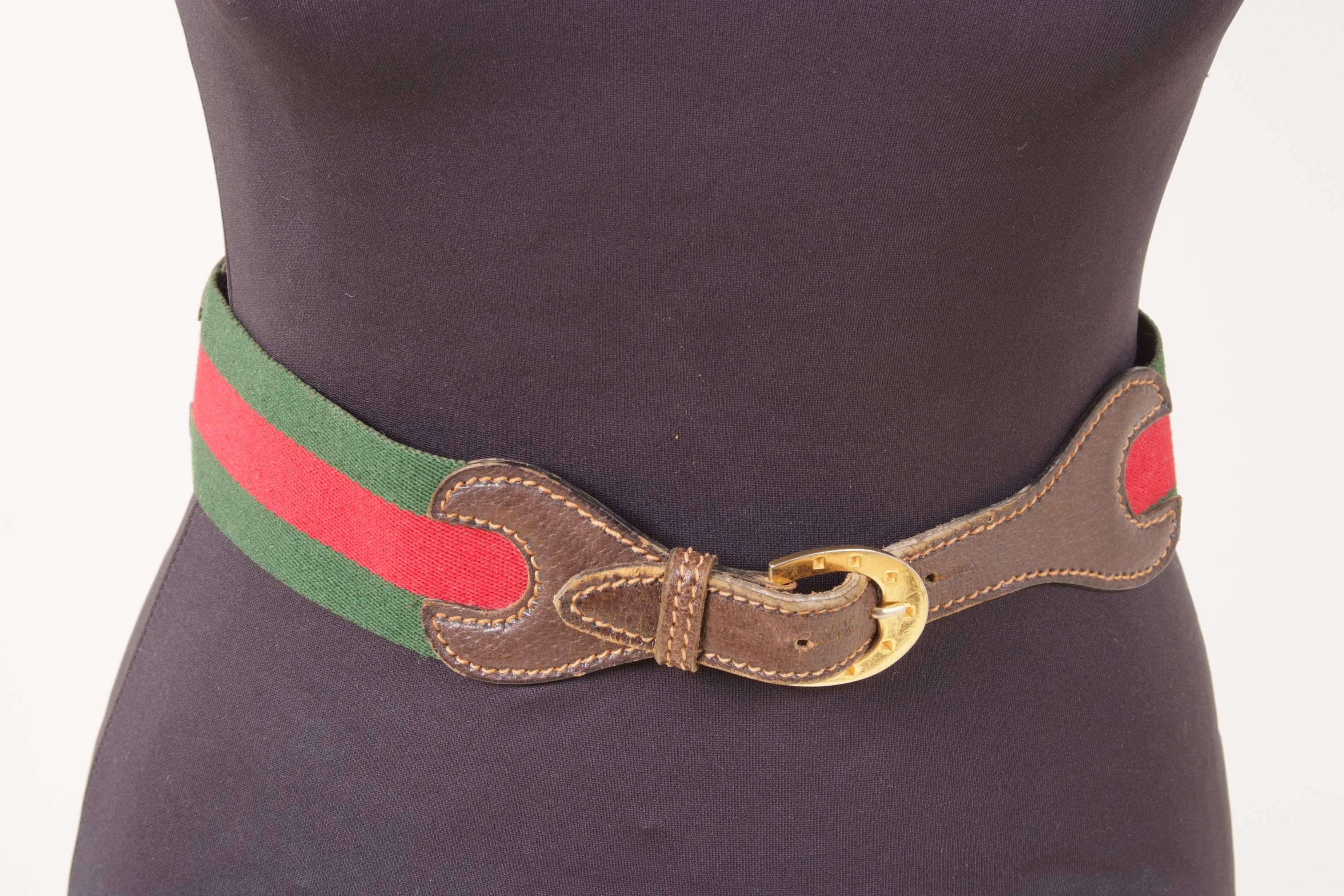 A 'GUCCI' BELT Green and red fabric with horse bit on leather in centre. Horse shoe gold buckle.