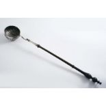 A GEORGE II/III PUNCH LADLE with a turned wooden handle and a circular embossed bowl inset with a